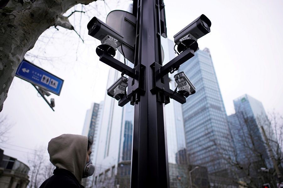 The use of advanced surveillance methods with the help of IT creates worries about greater intrusions of privacy by governments. In the photo, a man wearing a protective face mask walks under surveillance cameras as China is hit by an outbreak of the novel coronavirus, in Shanghai, China, on 4 March 2020. (Aly Song /File Photo/Reuters)
