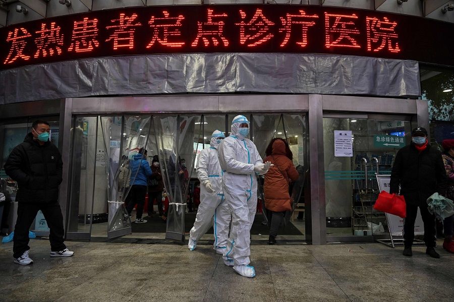 This file photo taken on 25 January 2020 shows medical staff members wearing protective clothing walking at the Wuhan Red Cross Hospital in Wuhan, Hubei, China. (Hector Retamal/AFP)