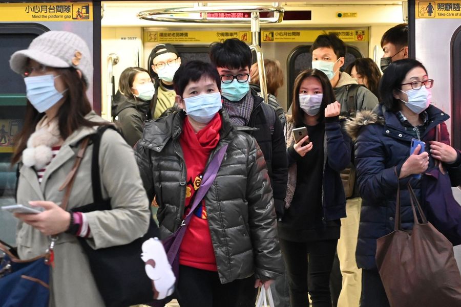 Amid the Covid-19 outbreak, mask-clad commuters are seen getting off a train at a train station in Taipei following the Lunar New Year holidays on 30 January 2020. (Sam Yeh/AFP)