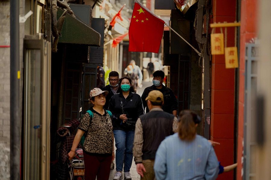 People walk along an alley in Beijing, China, on 20 April 2022. (Noel Celis/AFP)