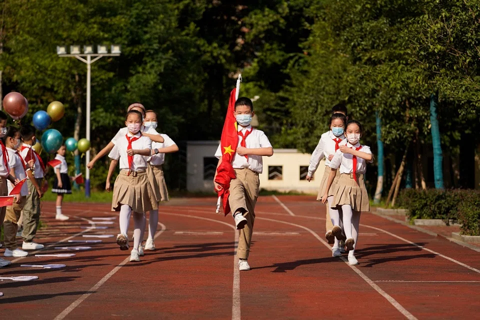 Students attend a flag-raising ceremony during the first day of the new semester in Wuhan, Hubei province, China, on 1 September 2021. (STR/AFP)
