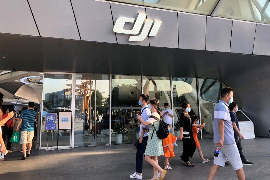 People wearing face masks walk past DJI's flagship store in Shenzhen, Guangdong province, China, 8 August 2020. (David Kirton/File Photo/Reuters)