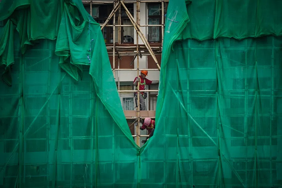 Workers remove scaffolding mesh from a building at Sui Wo Court in Sha Tin, following authorities' decision to remove the netting amid investigations into a deadly fire at Wang Fuk Court, in Hong Kong, China, 4 December 2025. (Vernon Yuen/Reuters)