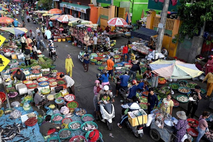 People shop at a fresh market in Phnom Penh on 13 June 2023. (Tang Chhin Sothy/AFP)