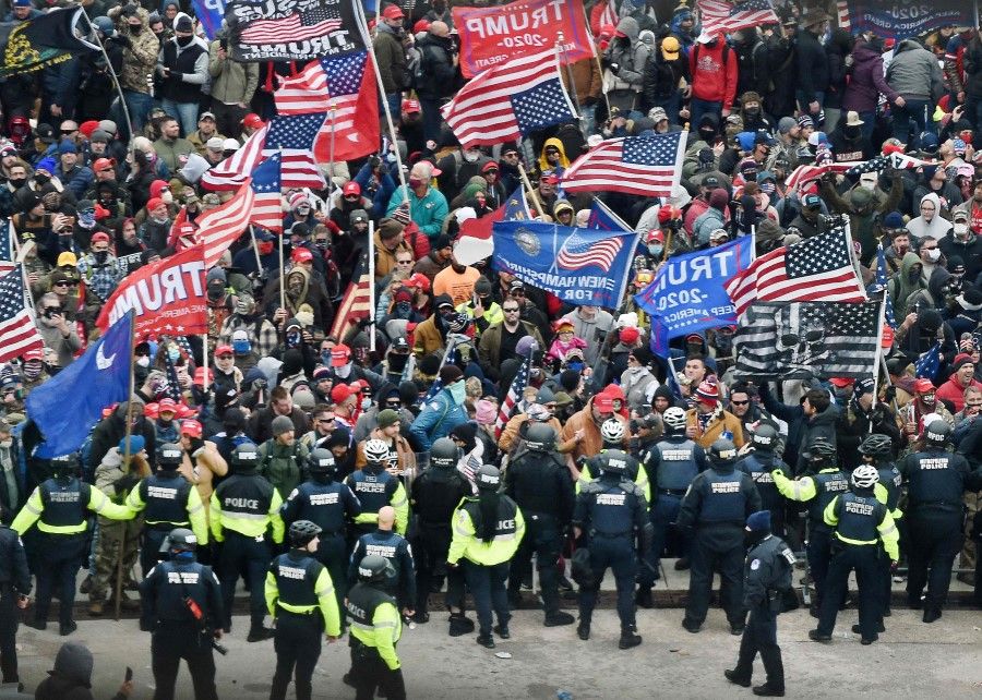 In this file photo taken on 6 January 2021, Trump supporters clash with police and security forces as they storm the US Capitol in Washington, DC. (Olivier Douliery/AFP)