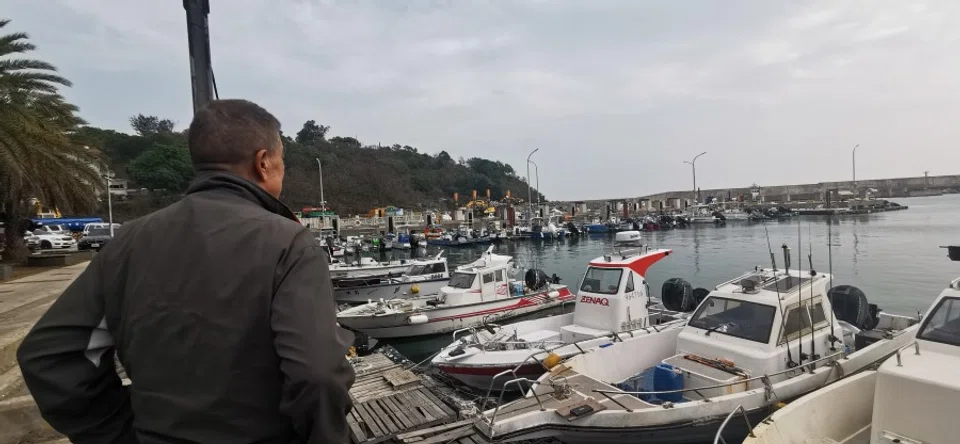 A fisherman looks out at hundreds of fishing boats moored at the dock in Little Kinmen, on 26 February 2024. (SPH Media)