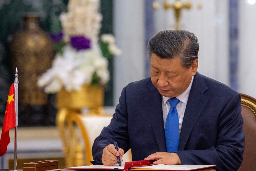 This handout picture provided by the Saudi Royal Palace shows Chinese President Xi Jinping signing an agreement with Saudi King Salman bin Abdulaziz (not pictured), in the capital Riyadh, on 8 December 2022. (Bandar al-Jaloud//AFP)