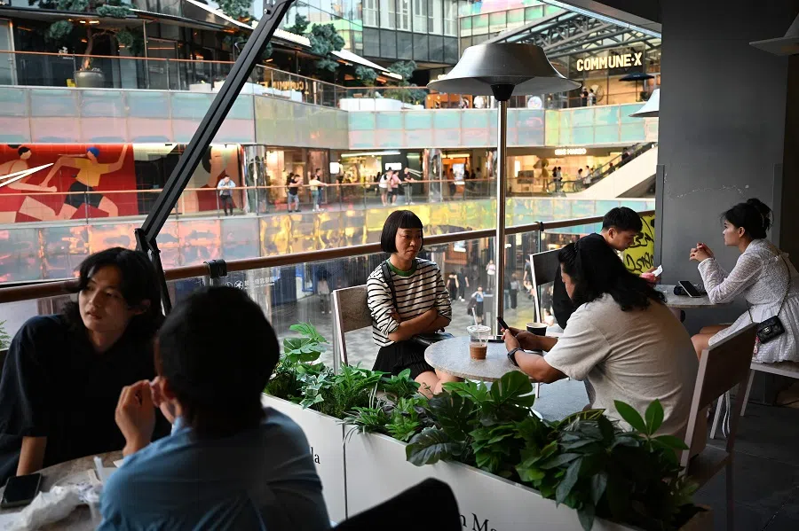 People sit at a restaurant in a shopping mall during a three-day Mid-Autumn Festival holiday in Beijing on 16 September 2024. (Greg Baker/AFP)