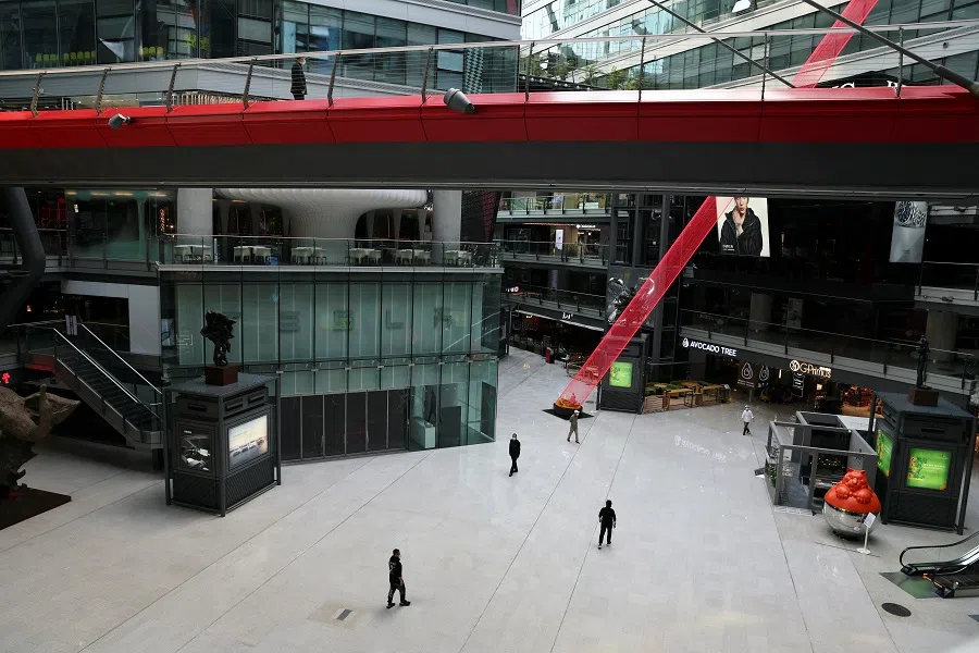 People walk inside a shopping mall where most shops are closed, amid the Covid-19 outbreak in Beijing, China, 9 May 2022. (Tingshu Wang/Reuters)