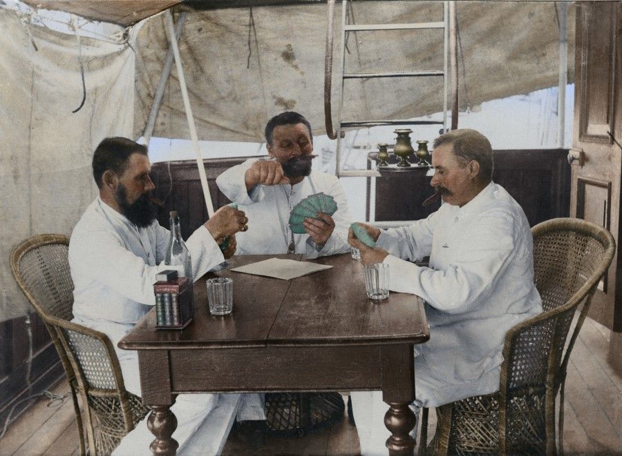 The German owner and crew of the coolie boat playing bridge in the cabin to pass the time over the long voyage. Most owners of the boats plying between Xiamen and Singapore were British and Americans. There were few German boat owners.
