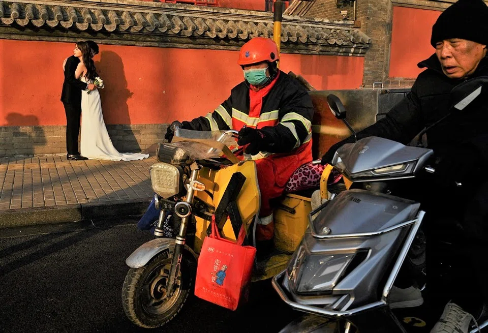 A couple poses during a pre-nuptial photography session in front of Drum Tower in Beijing, China, on 21 December 2021. (Noel Celis/AFP)