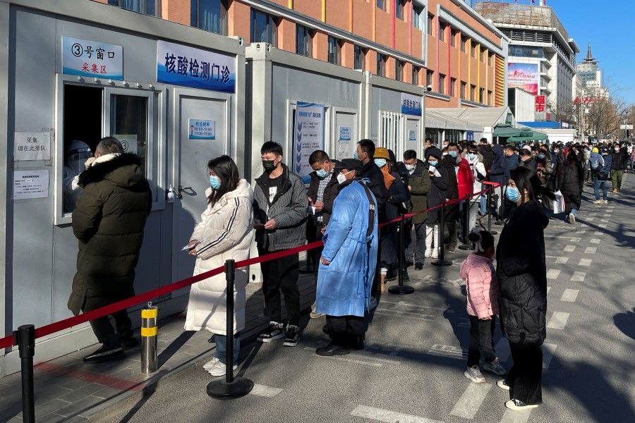 People line up to take nucleic acid tests at a testing site outside a hospital following the coronavirus disease (COVID-19) outbreak in Beijing, China, 17 January 2022. (Carlos Garcia Rawlins/Reuters)