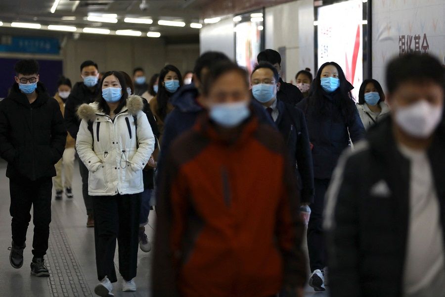 People walk at a subway station during morning rush hour in Beijing, China, 17 January 2022. (Tingshu Wang/Reuters)