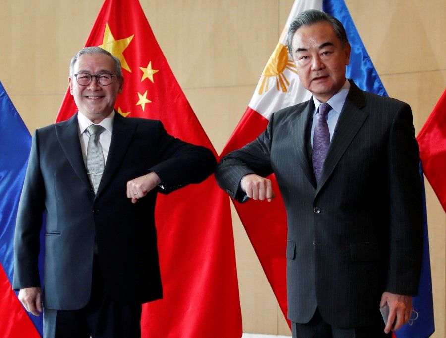 China's Foreign Minister Wang Yi and Philippine's Foreign Affairs Secretary Teodoro Locsin Jr., bump their elbows during a meeting in Manila, Philippines, 16 January 2021. (Francis Malasig/Pool via REUTERS)