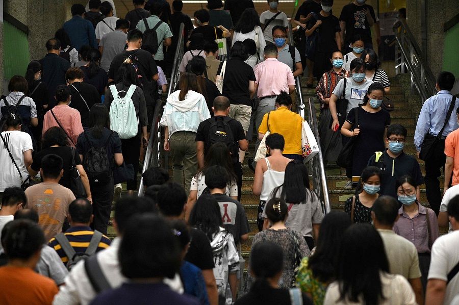 People walk up the stairs during rush hour at a subway in Beijing, China on 28 July 2021. (Noel Celis/AFP)