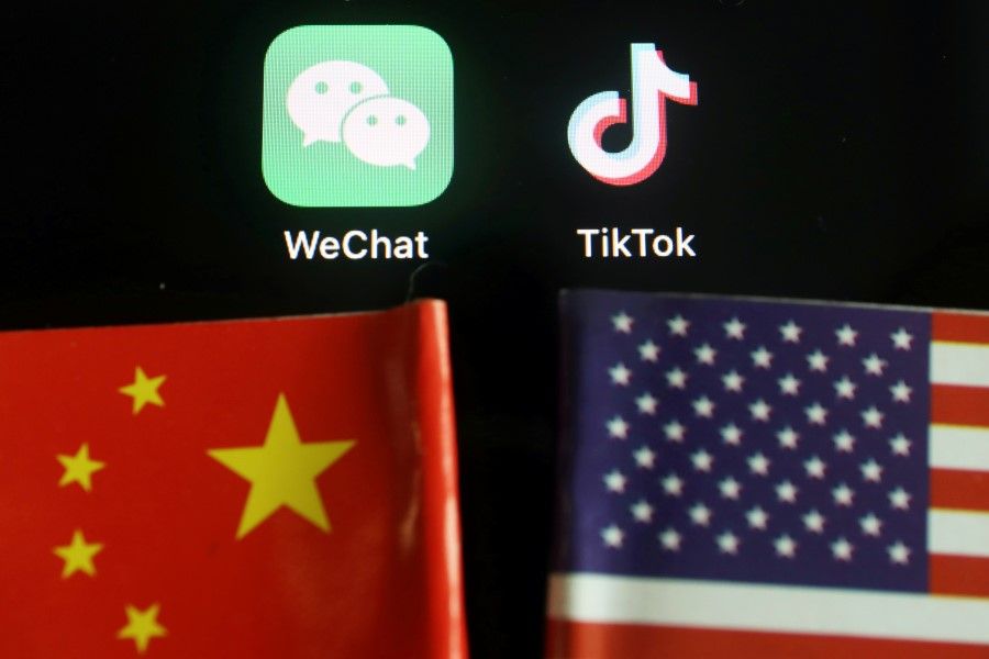 The messenger app WeChat and short-video app TikTok are seen near China and U.S. flags in this illustration picture taken 7 August 2020. (Florence Lo/REUTERS)