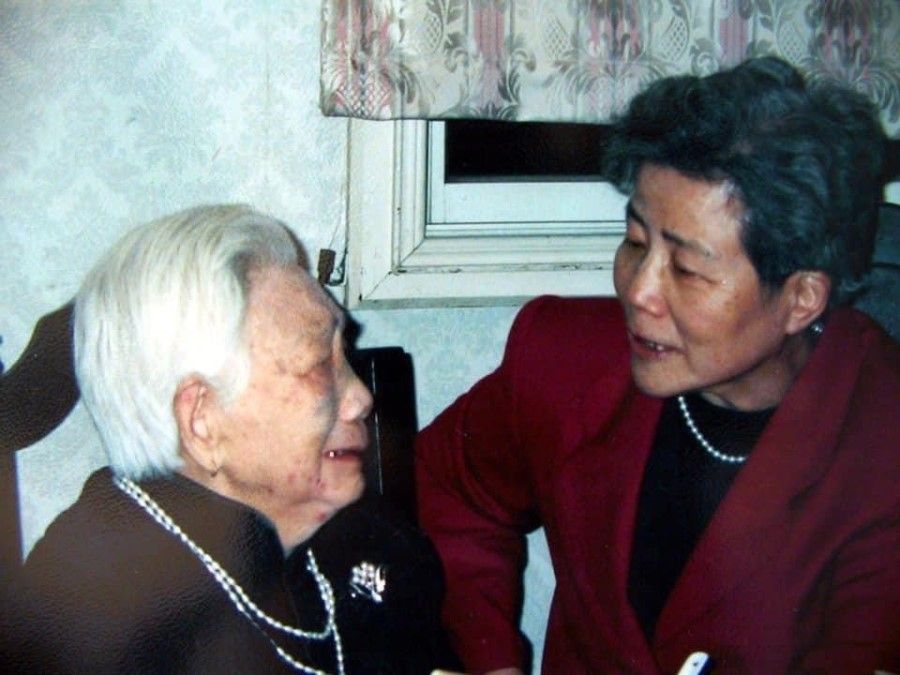 Lin Liyun (right) tearfully speaking to one of her elders in her hometown of Qingshui in 1999.