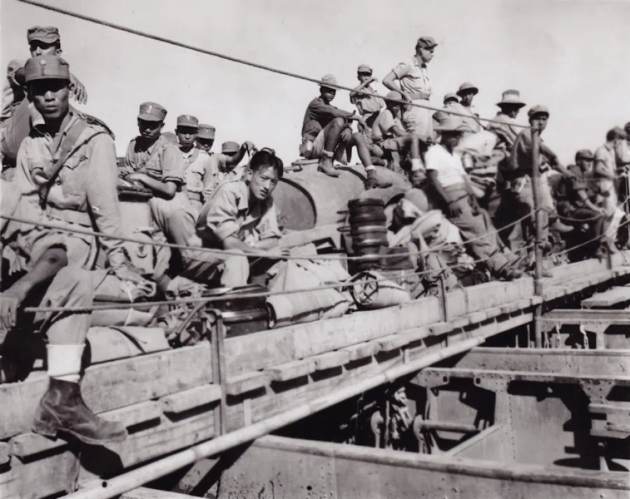 Li Xiaosheng (centre, without a cap) gazes at the camera.