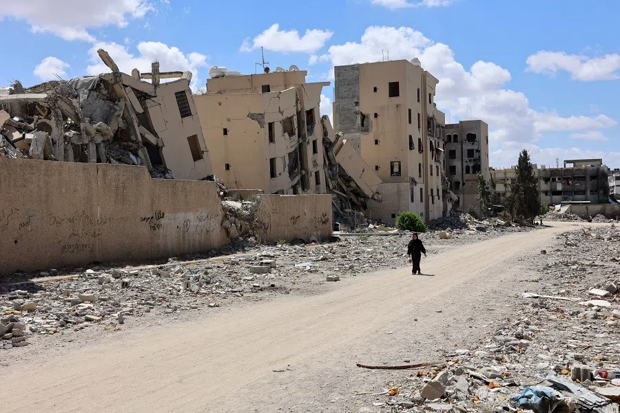 A Palestinian woman walks in front of buildings heavily damaged in Israeli bombing, in Beit Lahia in the northern Gaza Strip on 14 September 2024, amid the ongoing war between Israel and the Hamas militant group. (Omar Al-Qattaa/AFP)