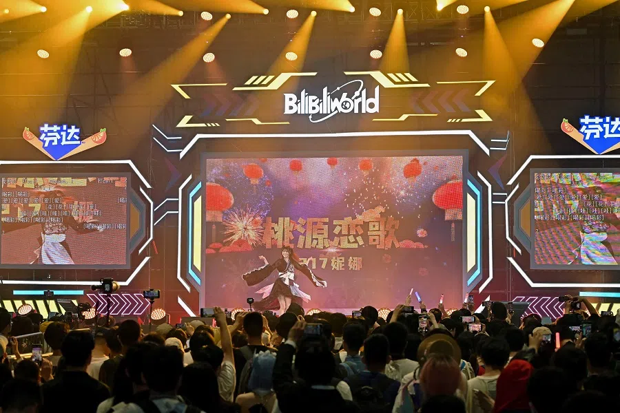 People watch a performance during the Bilibili World 2023 in Shanghai on 21 July 2023. (AFP)