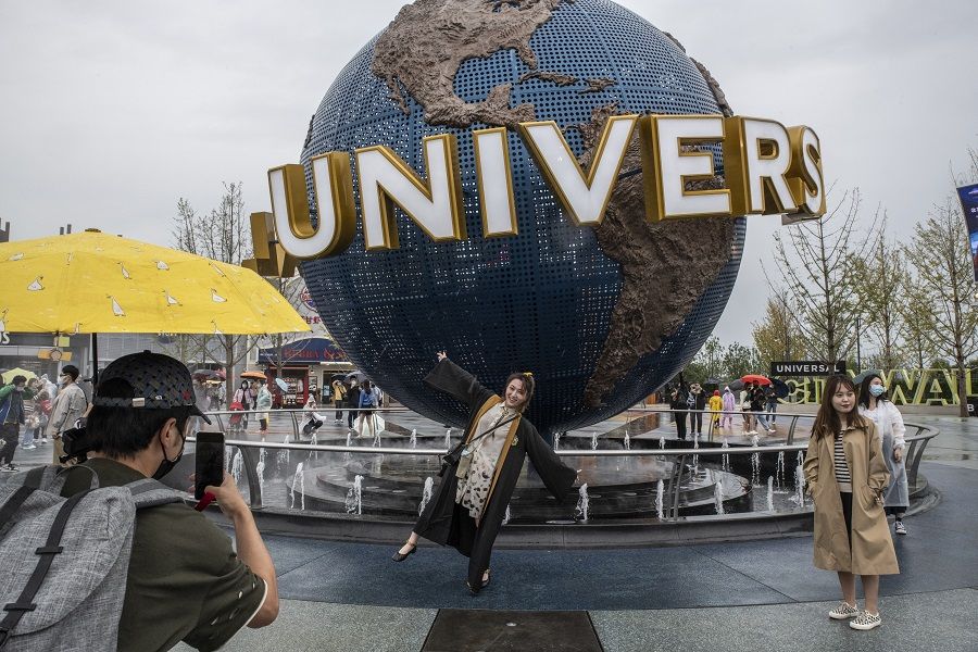Visitors pose for photos at the entrance of the Universal Studios Beijing theme park in Beijing, China, on 20 September 2021. (Gilles Sabrie/Bloomberg)