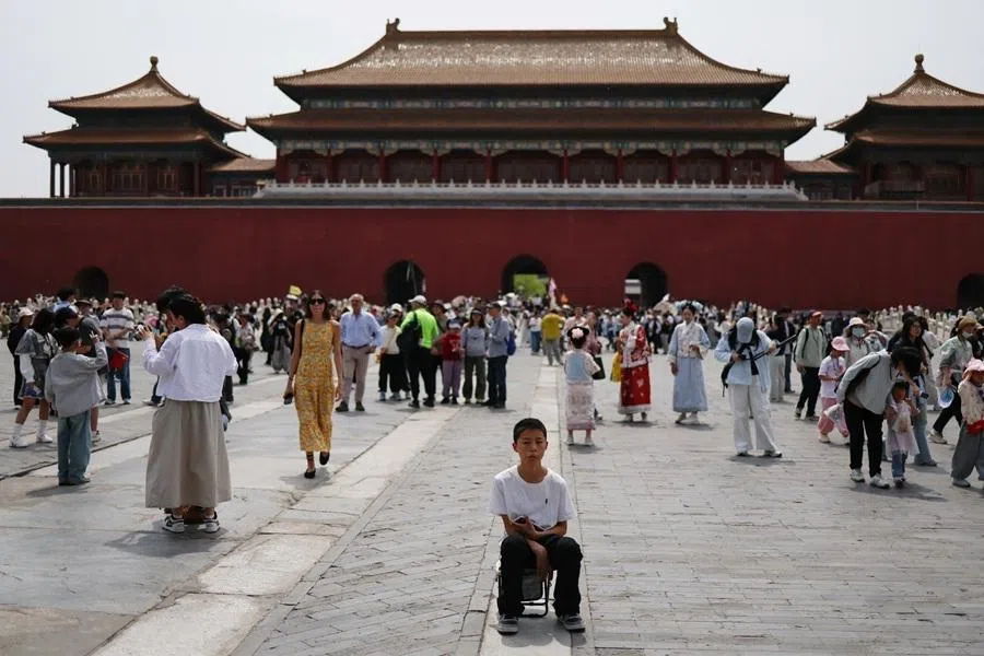 A tourist sits on a foldable chair at the Forbidden City on the first day of the five-day Labour Day holiday in Beijing, China, on 1 May 2026.