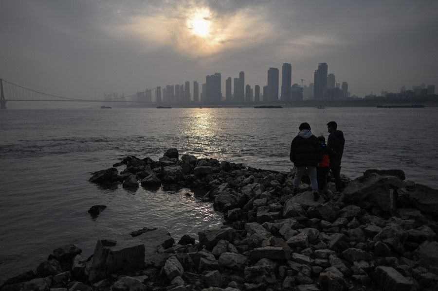 People visit the riverbank of the Yangtze River in Wuhan, China's central Hubei province on 2 February 2021. (Hector Retamal/AFP)
