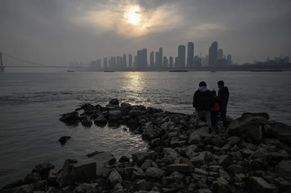 People visit the riverbank of the Yangtze River in Wuhan, China's central Hubei province on 2 February 2021. (Hector Retamal/AFP)