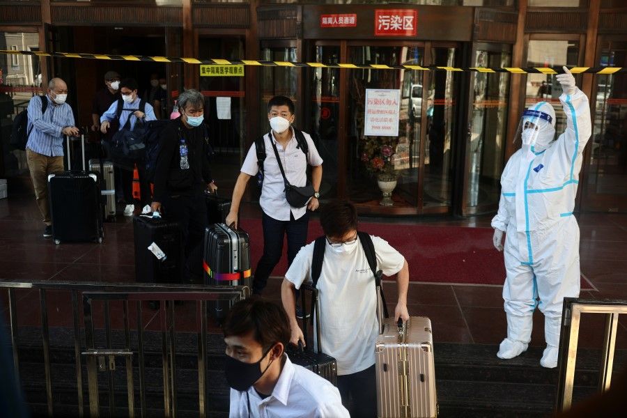People leave a quarantine hotel after completing their mandatory isolation for travellers entering China from abroad following the coronavirus disease (Covid-19) outbreak, in Dalian, Liaoning province, China, 29 September 2021. (Thomas Peter/Reuters)