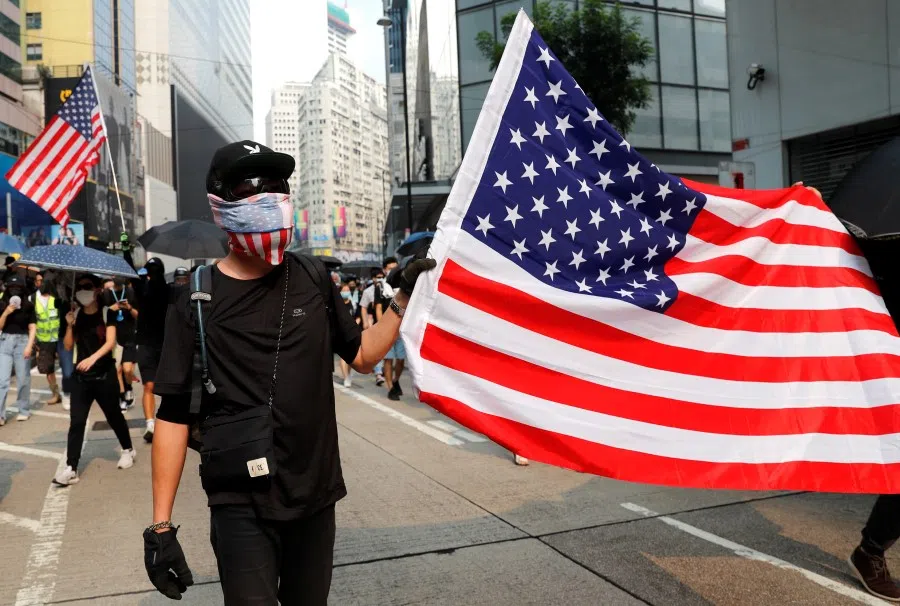 An anti-government protester carries an American flag during a demonstration in Hong Kong. (Tyrone Siu/REUTERS)