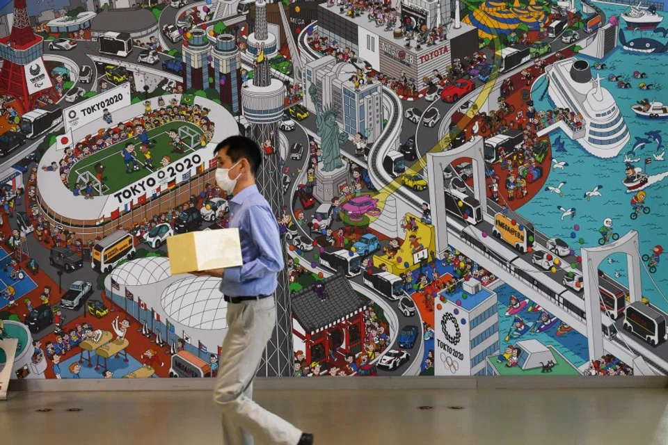 A man wearing a protective face mask walks past a mural inside Toyota's Mega Web showroom in Tokyo, 4 August 2020. (Noriko Hayashi/Bloomberg)