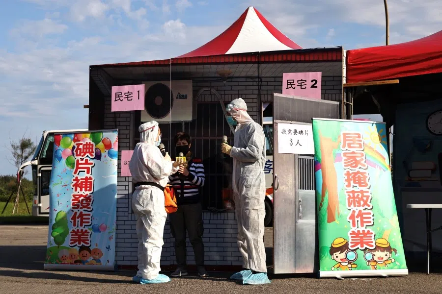Government staff distributes Potassium iodide, a salt of stable iodine that can help block radioactive iodine from being absorbed by the thyroid gland to a resident during an annual emergency drill to prepare for a nuclear disaster in Taipei, Taiwan, 10 November 2021. (Ann Wang/Reuters)