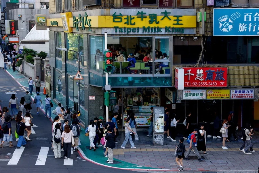 People walk in a shopping district in Taipei, Taiwan, on 8 November 2025. (Ann Wang/Reuters)