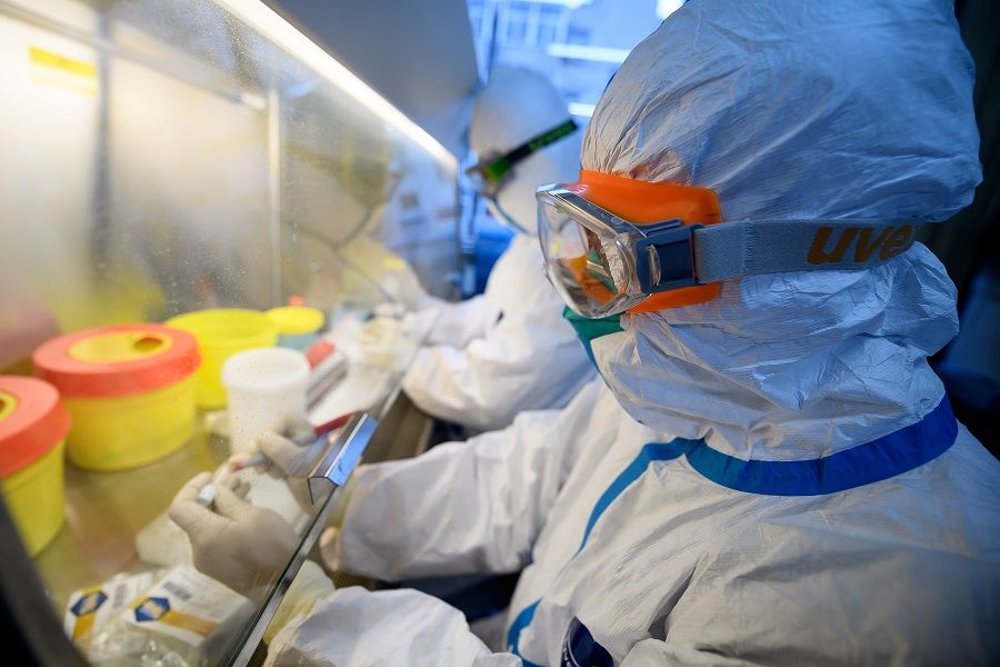 Workers in protective suits conduct RNA tests on specimens inside a laboratory at a centre for disease control and prevention, as the country is hit by a Covid-19 outbreak, in Taiyuan, Shanxi province, China, 14 February 2020. (CNS photo via Reuters)