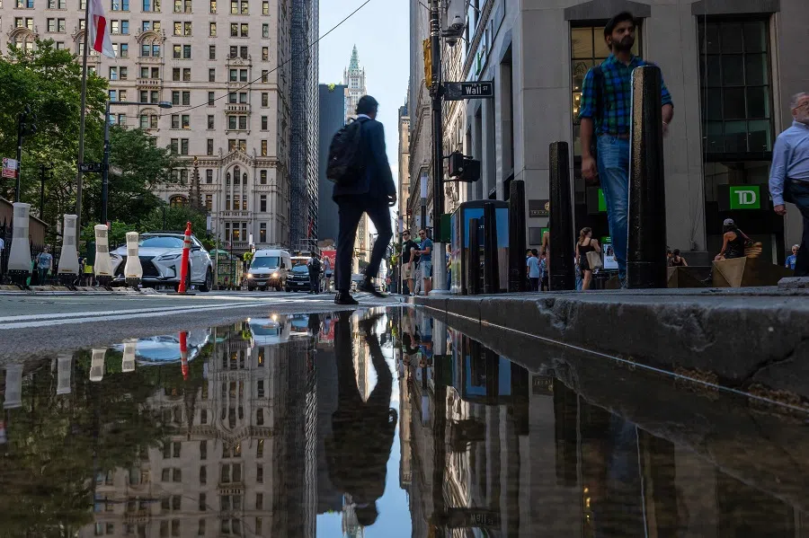 People walk through the Financial District near the New York Stock Exchange on 11 July 2024 in New York City. (Spencer Platt/Getty Images/AFP)