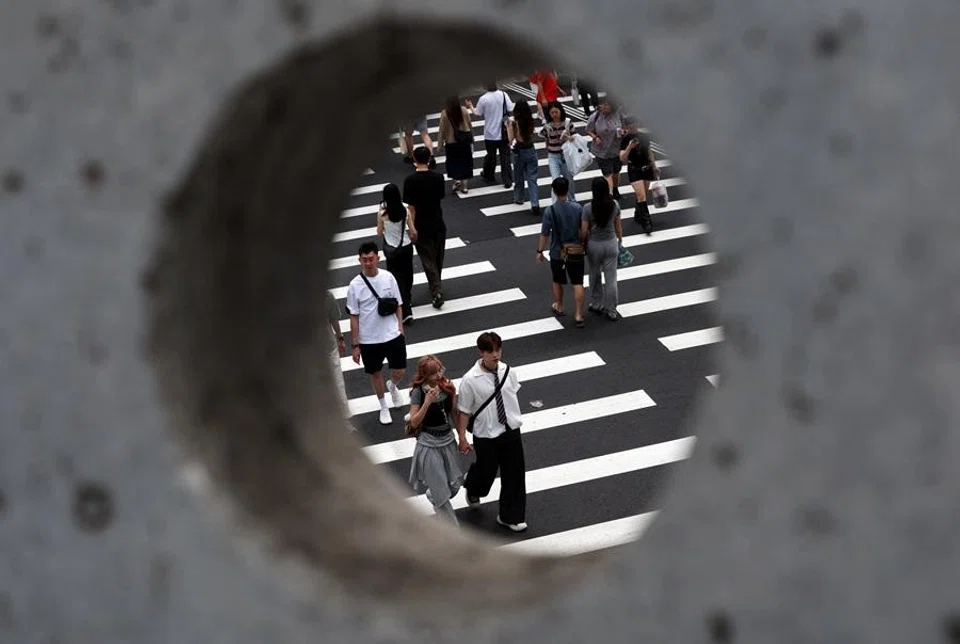 Pedestrians cross a street in Zhongshan district, Taipei, Taiwan, on 11 April 2026. (Edgar Su/Reuters)