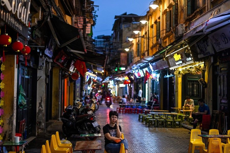 A woman waits for customers at the Ta Hien Beer Street in Hanoi on 10 March 2021. (Manan Vatsyayana/AFP)