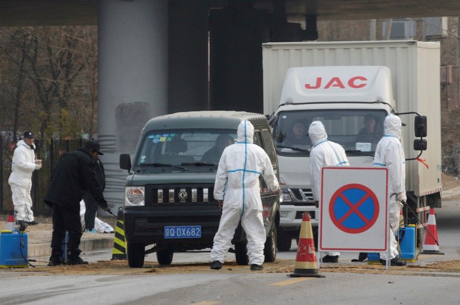 Workers in protective suits are seen at a checkpoint on a road leading to a village near a farm where African swine fever was detected, in Fangshan district of Beijing, China, November 23, 2018. (REUTERS)