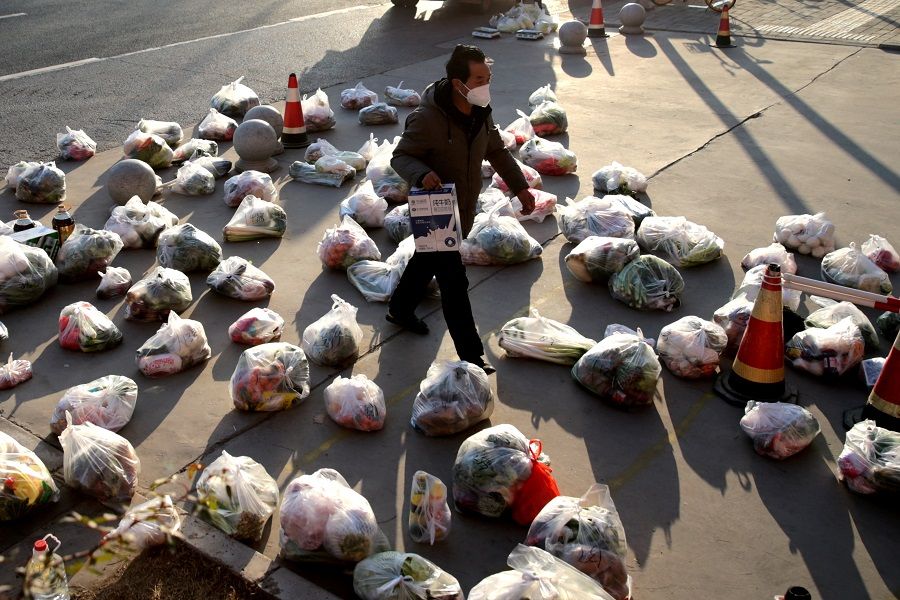 A worker prepares food supplies to be delivered to residents of a residential compound under lockdown, outside the compound following the coronavirus disease (Covid-19) outbreak in Xi'an, Shaanxi province, China, 29 December 2021. (CNS photo via Reuters)