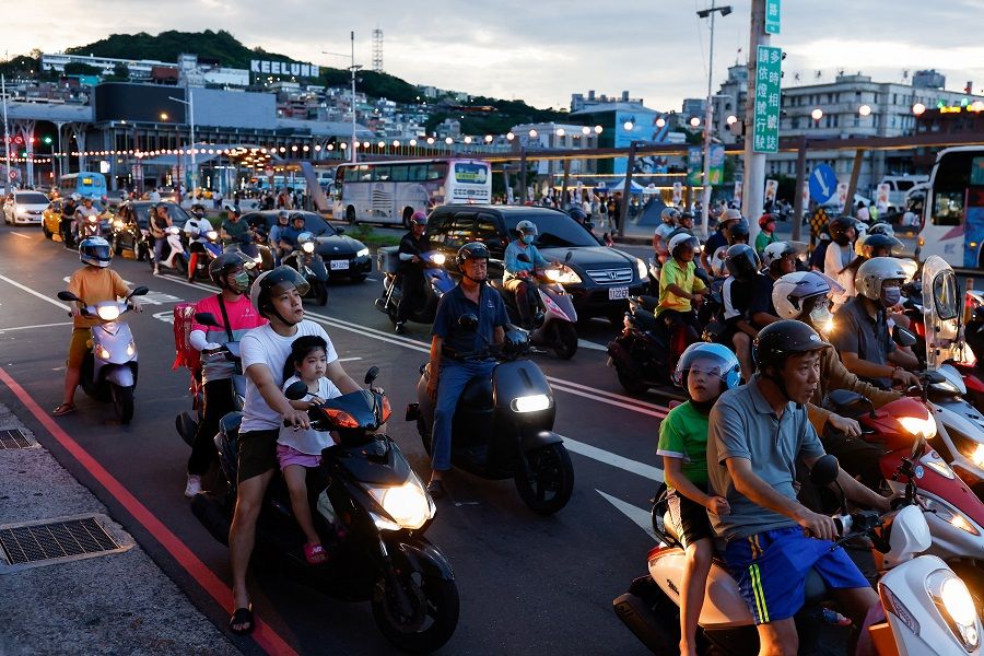 People wait at a red light while on their motorbikes in Keelung, Taiwan, on 19 August 2023. (Ann Wang/Reuters)