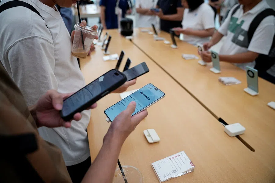A man checks a Huawei Mate 60 Pro smartphone displayed at a Huawei store in Shanghai, China, on 8 September 2023. (Aly Song/Reuters)