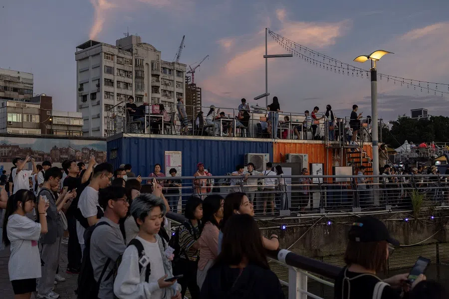 People watch the sunset at a wharf in Taipei, Taiwan, on 13 October 2024. (Tyrone Siu/Reuters)