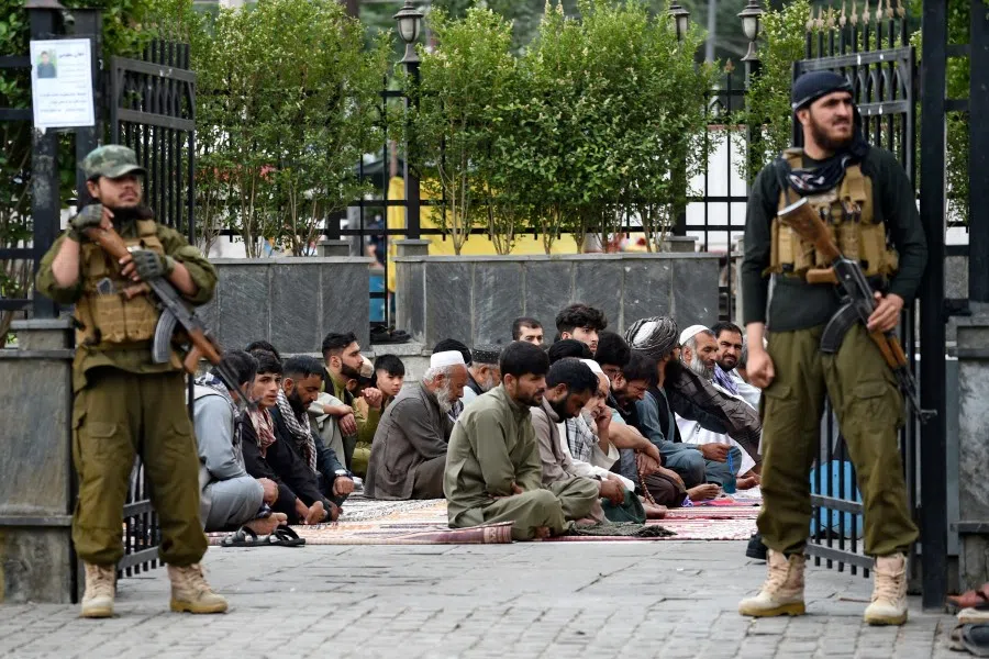 Taliban security personnel stand guard as men pray outside the Shah-e Doh Shamshira mosque ahead of Muslim festival Eid al-Adha in Kabul on 28 June 2023. (Ahmad Sahel Arman/AFP)