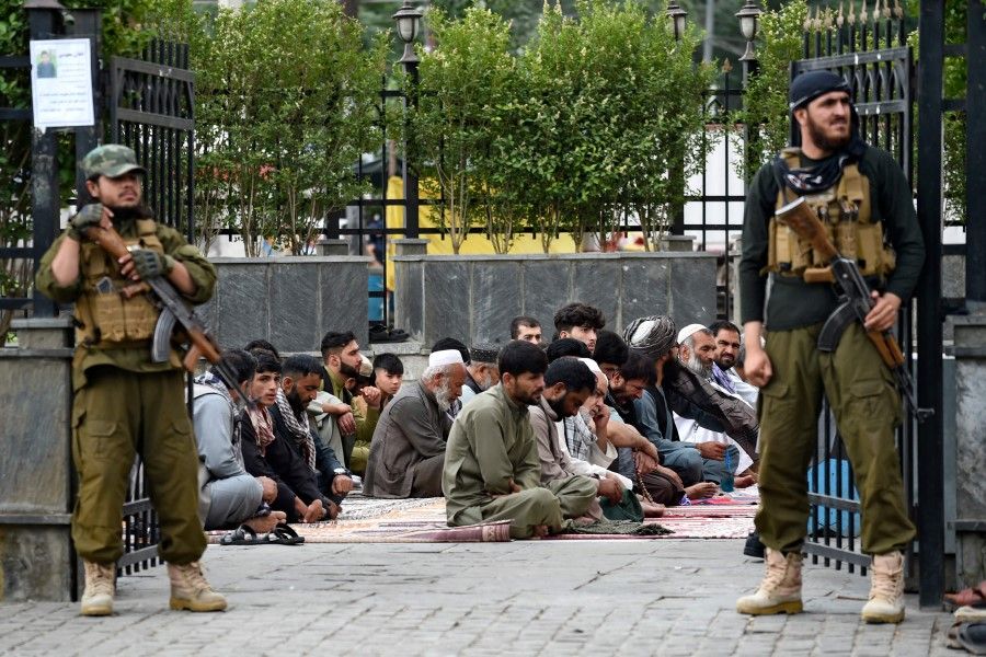 Taliban security personnel stand guard as men pray outside the Shah-e Doh Shamshira mosque ahead of Muslim festival Eid al-Adha in Kabul on 28 June 2023. (Ahmad Sahel Arman/AFP)
