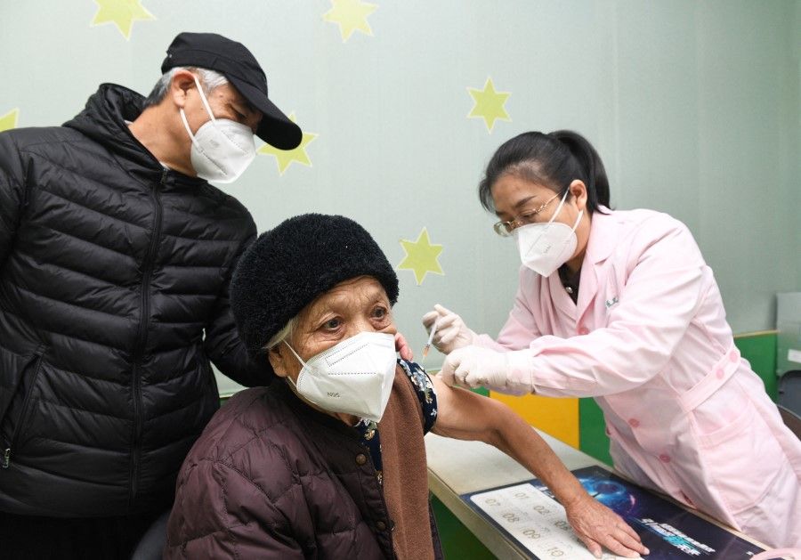 A medical worker administers a dose of the vaccine against coronavirus disease (Covid-19) to an elderly person at a community health service centre in Shijiazhuang, Hebei province, China, 12 December 2022. (China Daily via Reuters)