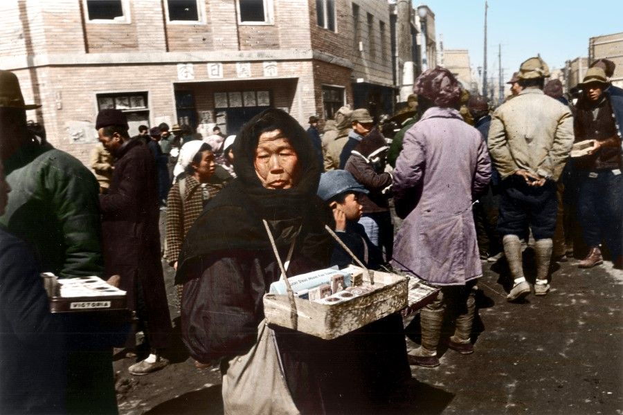 An elderly Japanese woman selling cigarettes in a city in northeast China, 1946. After Japan lost the war, Japanese residents went instantly from first-class residents to the poverty-stricken people of a defeated country, waiting for the Allies to repatriate them.