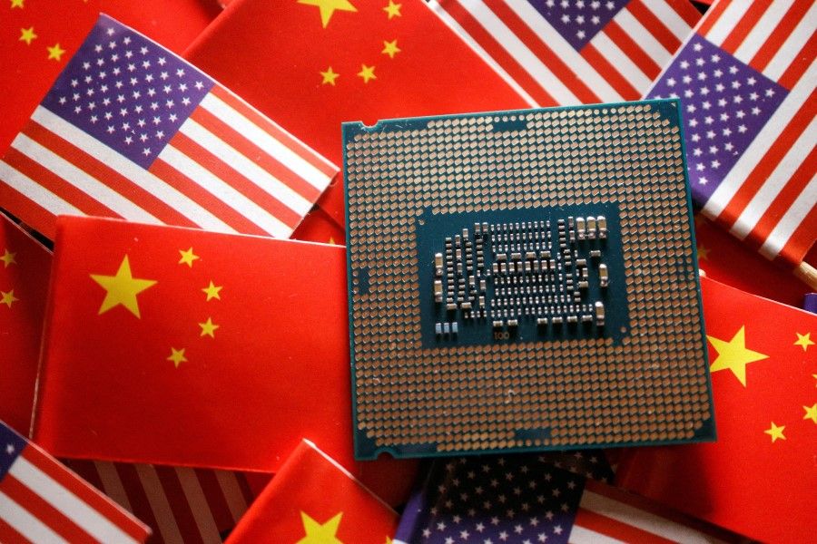 A central processing unit (CPU) semiconductor chip is displayed among flags of China and the US, in this illustration picture taken on 17 February 2023. (Florence Lo/Reuters)