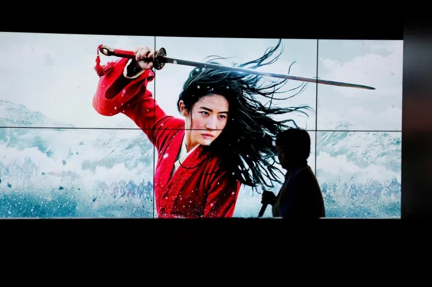 A cleaner walks past screens promoting Disney's movie Mulan as the film opens in China, at a cinema in Beijing, China, 11 September 2020. (Florence Lo/Reuters)