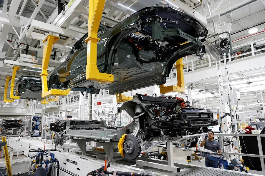An employee works on an assembly line at startup Rivian Automotive's electric vehicle factory in Normal, Illinois, US, 11 April 2022. (Kamil Krzaczynski/File Photo/Reuters)