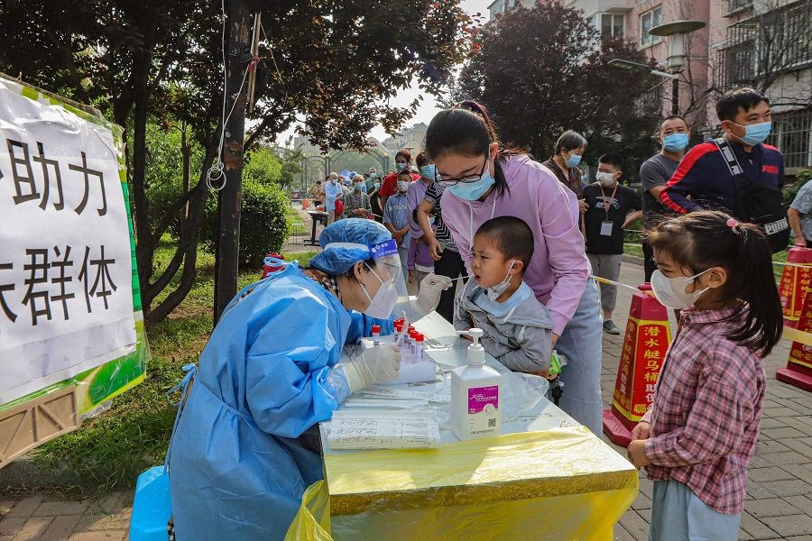 This photo taken on 30 August 2022 shows a health worker taking a swab sample from a child to be tested for Covid-19 in Tianjin, China. (CNS/AFP)